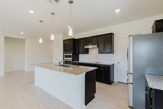 a kitchen with kitchen island a sink stainless steel appliances and cabinets