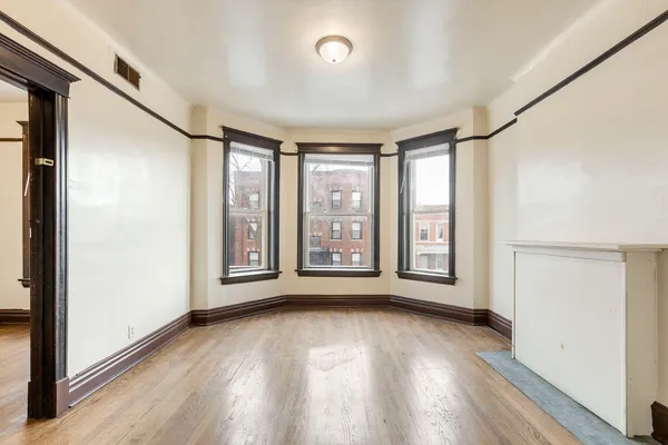 a view of a room with wooden floor and a window