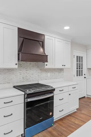 a kitchen with granite countertop a stove microwave and cabinets