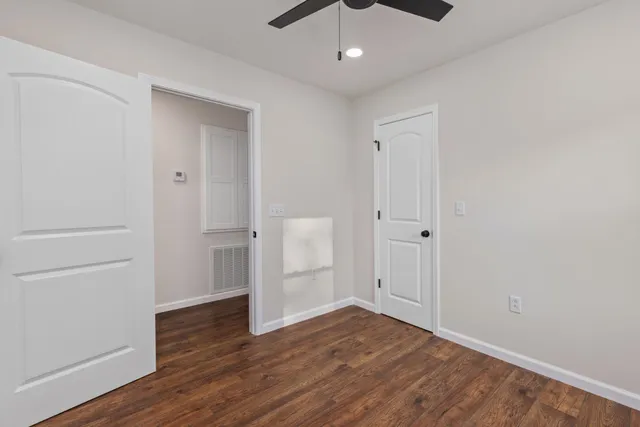 an empty room with wooden floor and cabinet