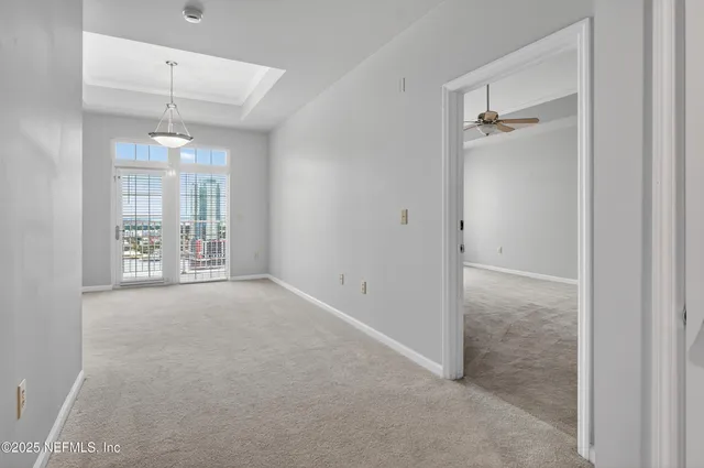 an empty room with closet and a chandelier fan