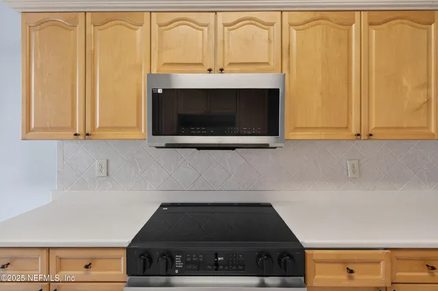 a view of an empty room with a fireplace and a window