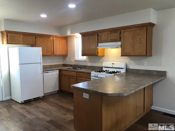 a kitchen with a sink a stove a refrigerator and cabinets