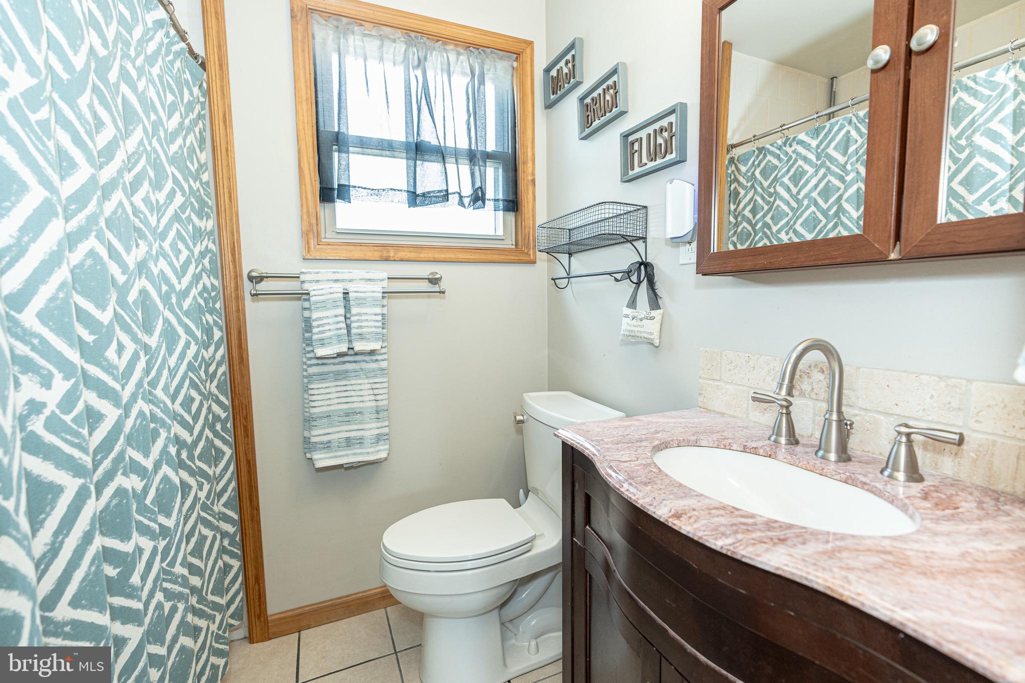 1510 Seling Avenue Rosedale, MD 21237 - Photo 9 of 24 a bathroom with a granite countertop toilet sink and mirror