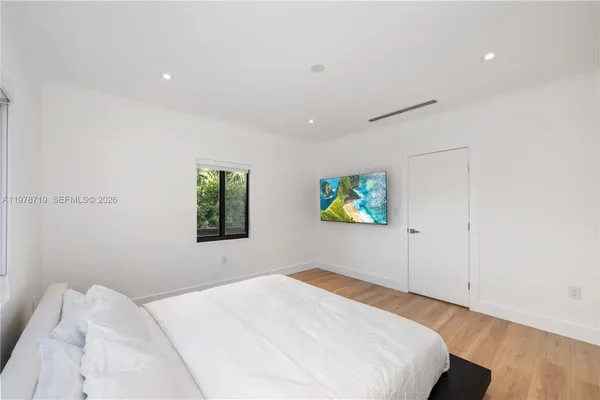 a bedroom with a bed and painting on the wall