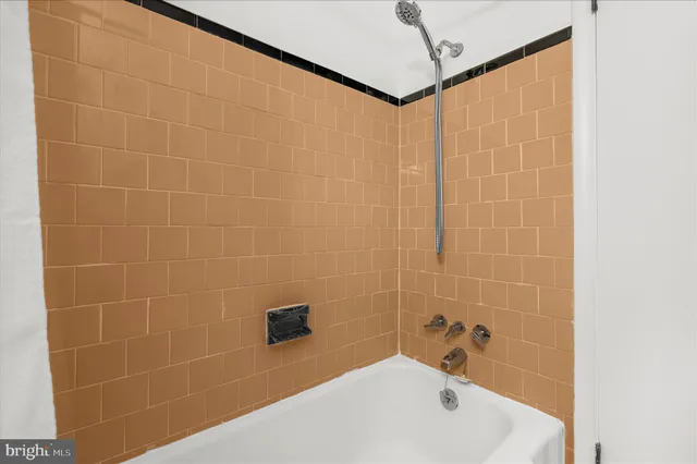 an empty room with a chandelier fan and windows