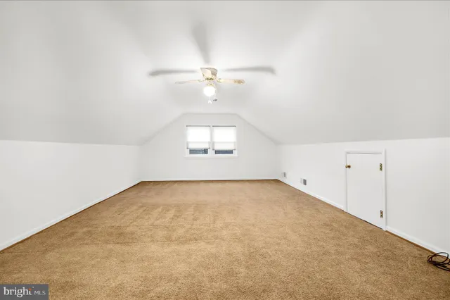an empty room with a ceiling fan and closet area