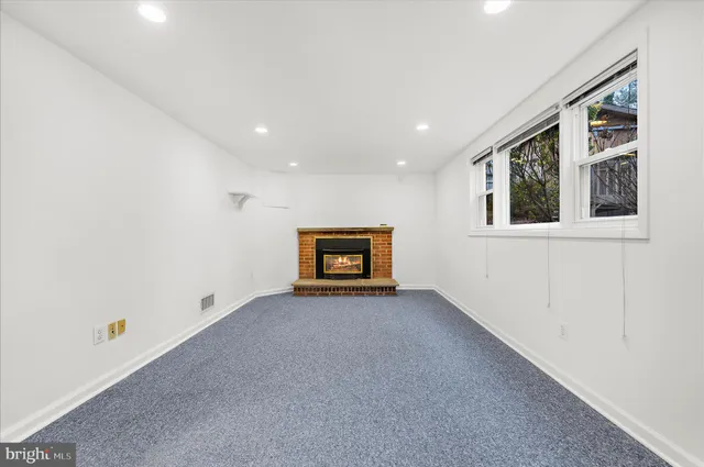 an empty room with white walls and windows