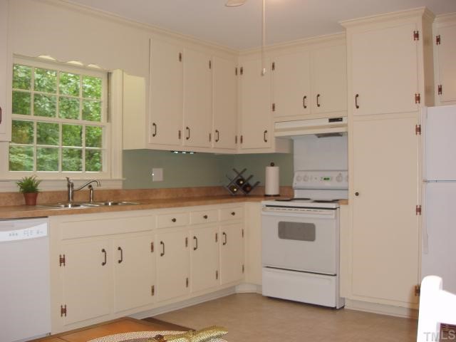 4115 Laurel Ridge Drive Raleigh, NC 27612 - Photo 3 of 12 a kitchen with granite countertop white cabinets and white appliances