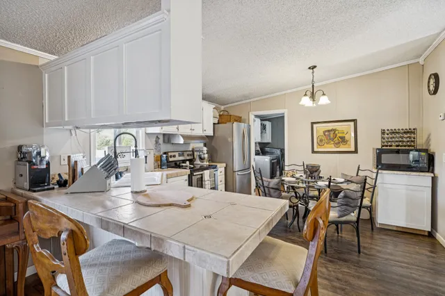 a kitchen with a dining table chairs and white cabinets