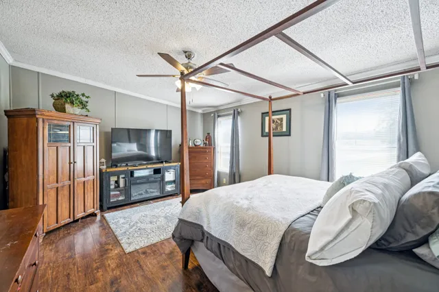 a spacious bedroom with a bed and a flat screen tv