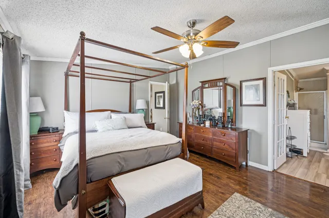 a bedroom with a bed and wooden floor