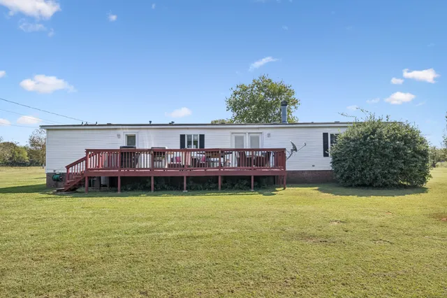 a view of a house with yard and sitting area