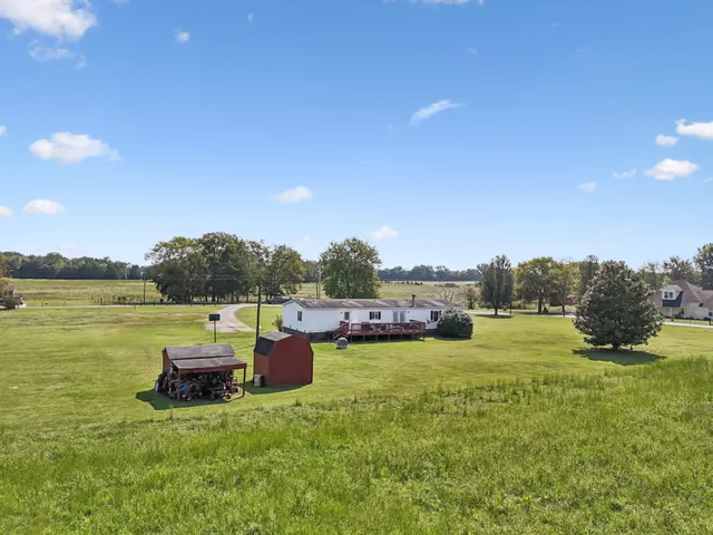a view of a lake with lawn chairs and a table