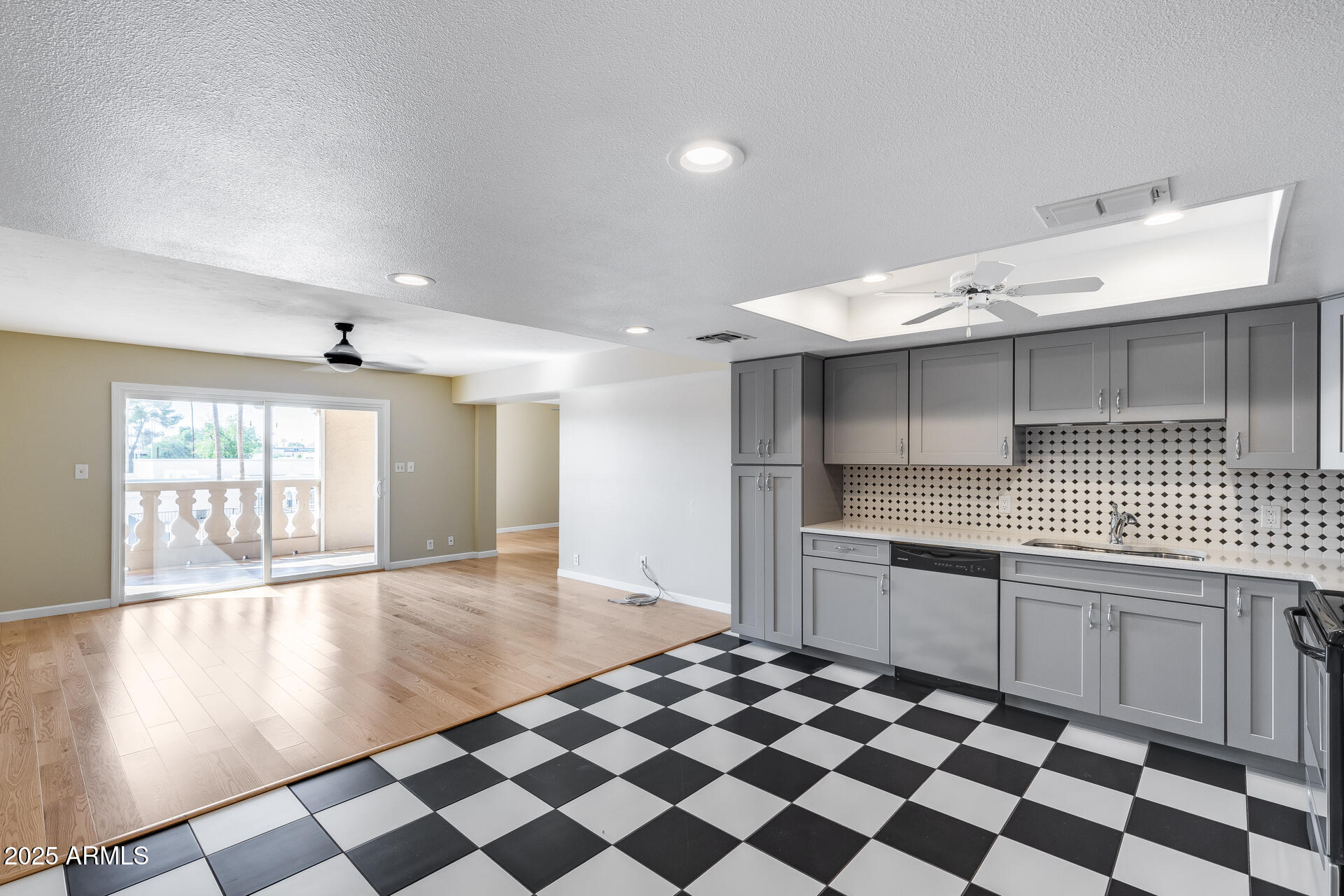 7820 East Camelback Road, Unit 211 Scottsdale, AZ 85251 - Photo 3 of 52 a kitchen with a checkered floor and white cabinets
