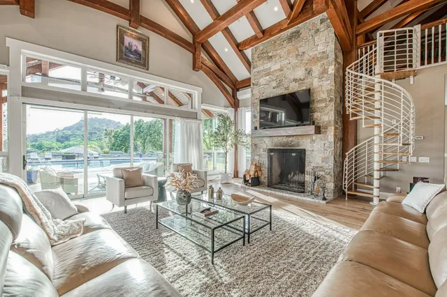 a living room with furniture a fireplace and a floor to ceiling window