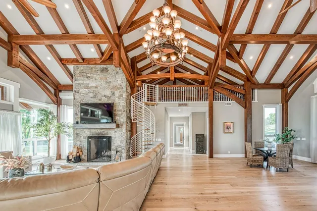 a living room with furniture a fireplace and a floor to ceiling window
