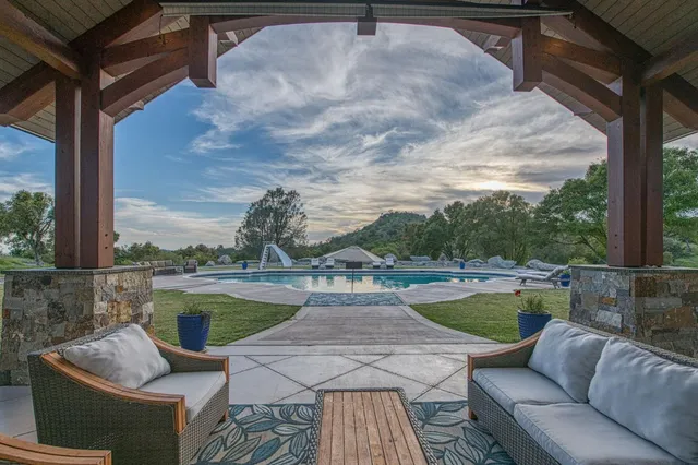 a view of a swimming pool with couches and wooden floor