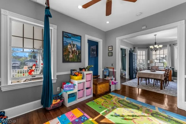 a playing room with lots of furniture and wooden floor