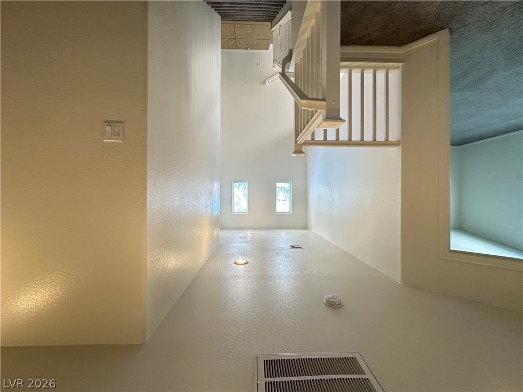 7305 Prussian Green Street Las Vegas, NV 89139 - Photo 6 of 23 An inviting entry hallway features light-toned flooring, subtle wall lighting, and a graceful staircase leading to the upper level.
