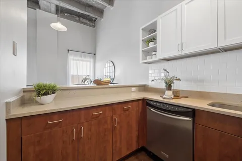 a kitchen with stainless steel appliances granite countertop a sink dishwasher and cabinets with wooden floor