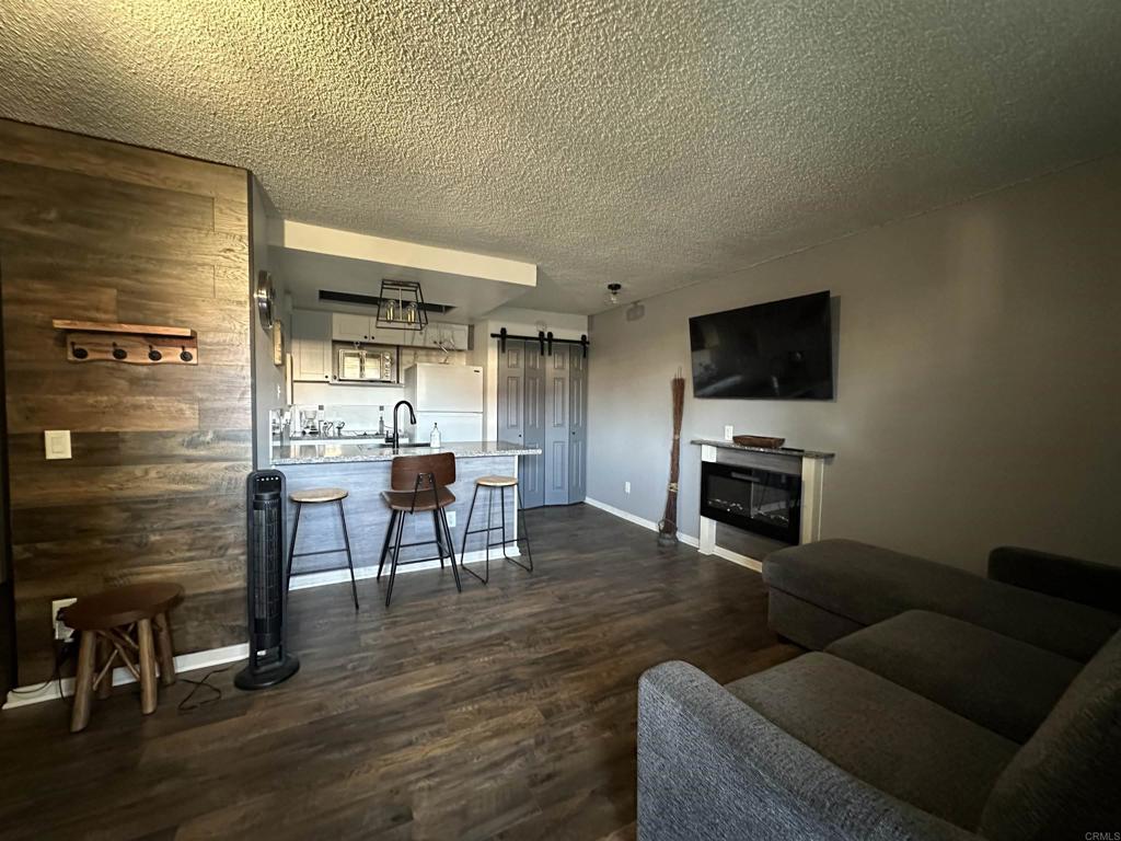 2033 Dairy Mart Road, Unit 13 San Ysidro, CA 92173 - Photo 5 of 14 a living room with furniture a fireplace and a flat screen tv