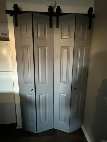 a kitchen with a sink dishwasher and a refrigerator with wooden floor