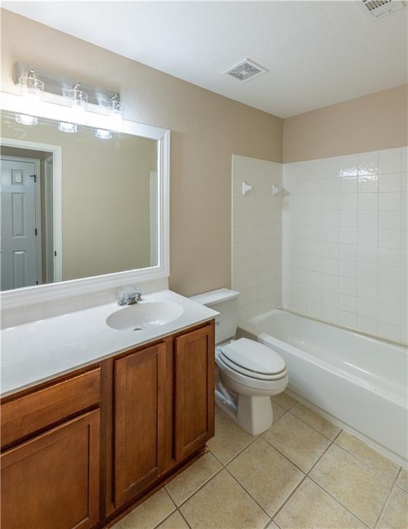 12017 Springs Head Loop Austin, TX 78717 - Photo 20 of 25 A compact bathroom with a vanity, toilet, and bathtub, featuring tiled floors.