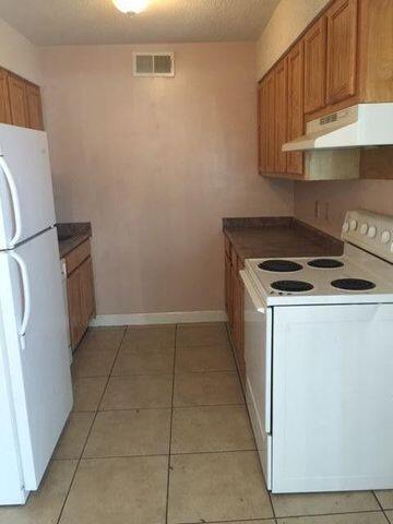 210 Pelham Road, Unit 107A Fort Walton Beach, FL 32547 - Photo 3 of 6 a kitchen with a stove top oven and cabinets