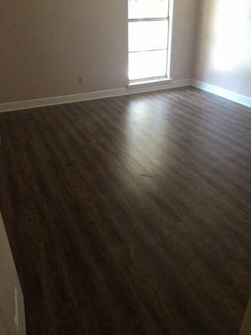 210 Pelham Road, Unit 107A Fort Walton Beach, FL 32547 - Photo 6 of 6 a view of an empty room with wooden floor and a window