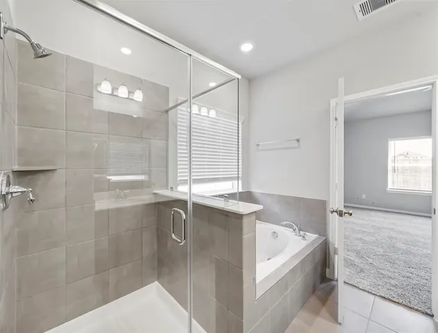 a bathroom with a granite countertop bathtub shower and sink