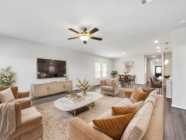 a living room with furniture kitchen view and a flat screen tv