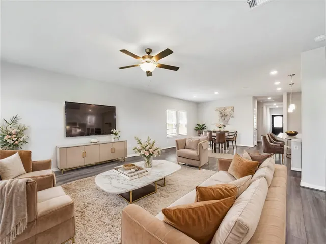 a living room with furniture kitchen view and a flat screen tv