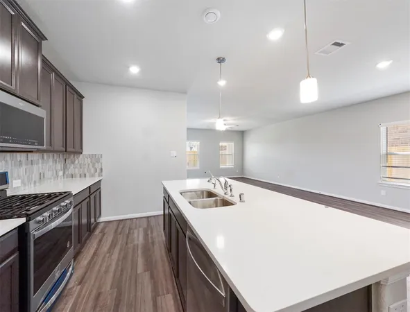 a kitchen with a sink stove and microwave
