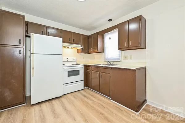 a kitchen with a refrigerator sink and cabinets