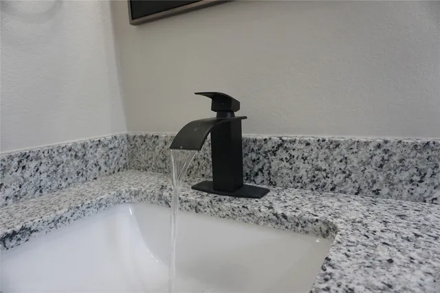 a bathroom with a granite countertop sink and a white stove