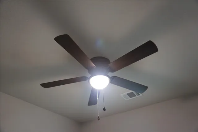 a view of an empty room with a ceiling fan