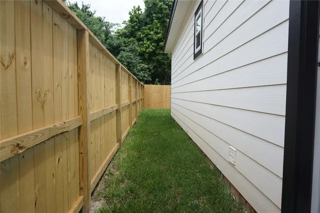a view of a backyard with potted plants and wooden fence