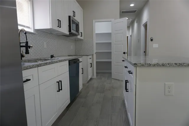 a kitchen with stainless steel appliances granite countertop a refrigerator and a stove