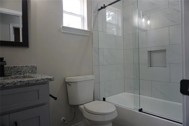 a bathroom with a granite countertop toilet a sink and bathtub