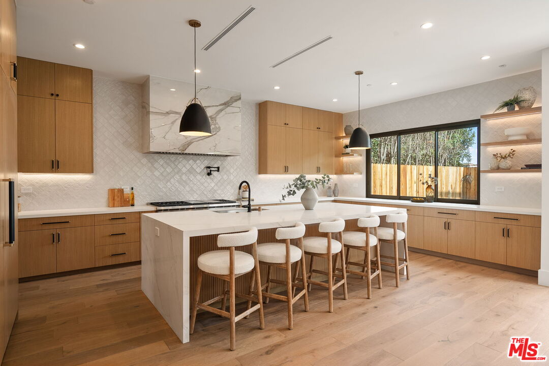 1742 Preuss Road Los Angeles, CA 90035 - Photo 15 of 50 a kitchen with cabinets a sink dishwasher a dining table and chairs with wooden floor