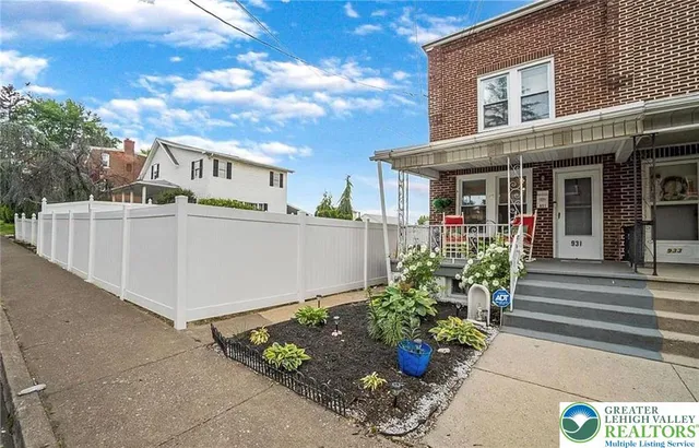 a front view of a house with a yard and potted plants