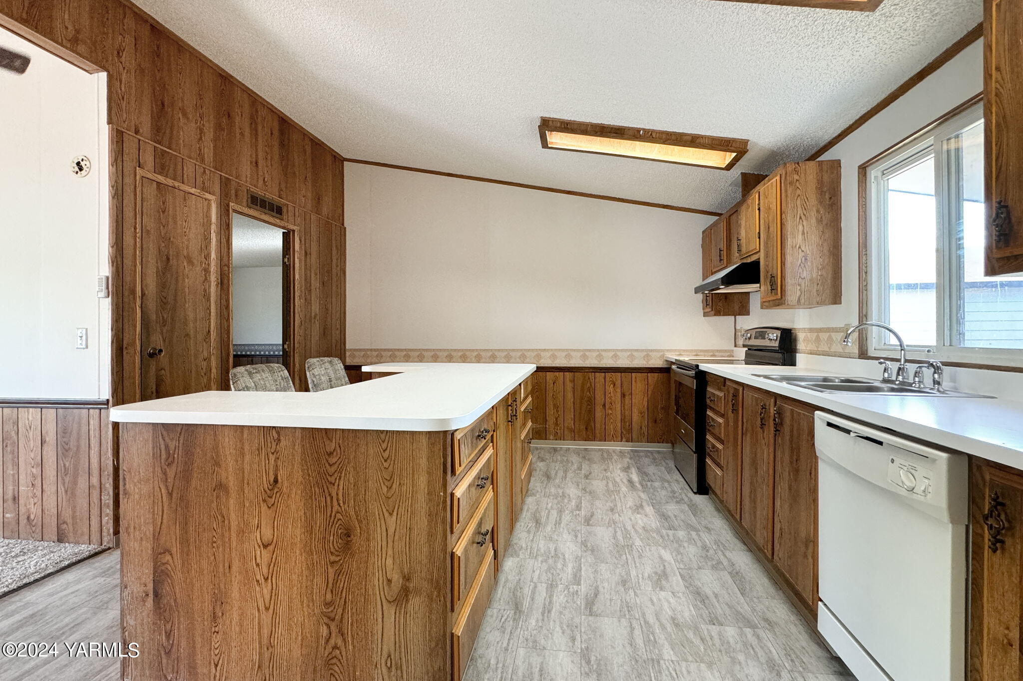 3701 Gun Club Road, Unit 54 Yakima, WA 98901 - Photo 10 of 17 a kitchen with kitchen island a counter top space a sink a window and stainless steel appliances