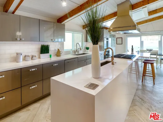 a kitchen with a sink a stove and cabinets