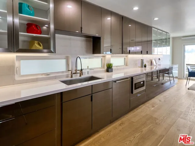 a kitchen with stainless steel appliances granite countertop a sink a stove and a refrigerator