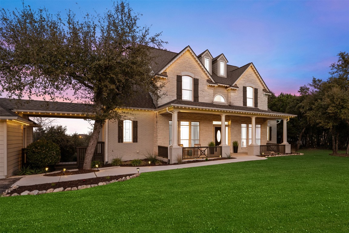 a front view of a house with a garden and yard