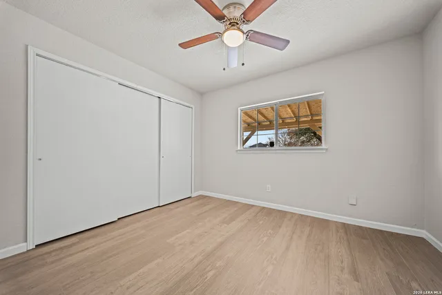 an empty room with a window and a ceiling fan