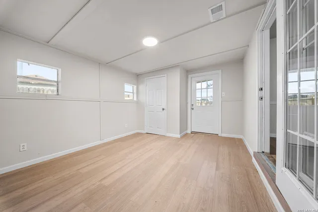 a view of empty room with wooden floor