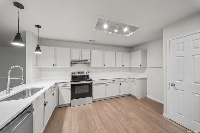 a kitchen with granite countertop white cabinets and white appliances