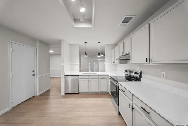 a kitchen with a sink stove and cabinets